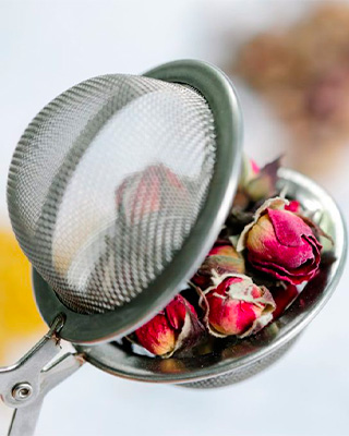 Infusion de fleurs séchées dans un diffuseur, sélection de tisanes Crêperie Les Deux Frères aux Sablettes